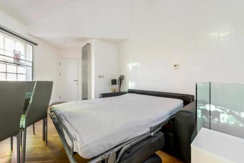 a hospital bed in a room with a table at Beautiful 1 Bedroom penthouse Flat in London