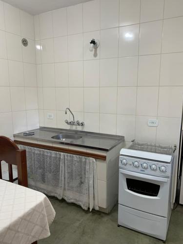 uma cozinha com um lavatório e um fogão em Casa da Inês em Monte Verde
