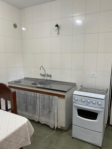 a kitchen with a sink and a stove at Casa da Inês exclusiva para 01 ou 02 casais ou família in Monte Verde