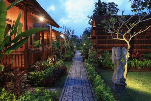 a garden path in front of a house at night at The Dukuh Retreat in Tabanan