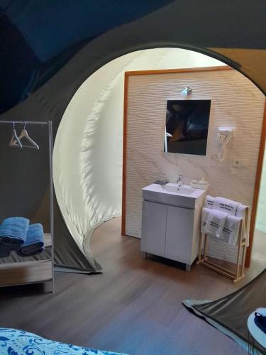 a bathroom with a tent with a sink and a mirror at Bolhas da Montanha in Ribas