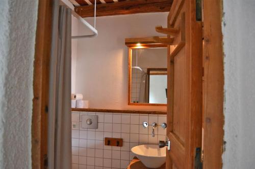 La salle de bains est pourvue d'un lavabo et d'un miroir. dans l'établissement Langley Hotel La Vieille Ferme, à La Salle Les Alpes