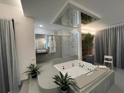 a white bathroom with a tub and a sink at La Casba in Paola