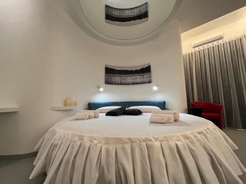 a bedroom with a large white bed with towels on it at La Casba in Paola