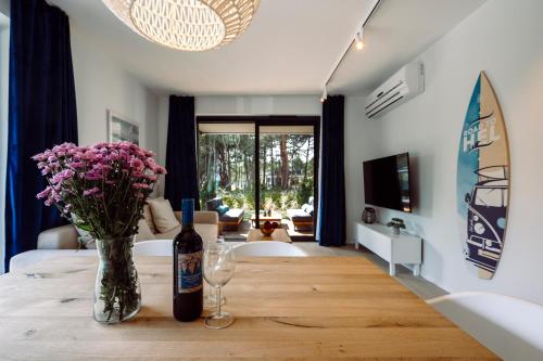 a room with a table with a bottle of wine and flowers at Apartamenty Wydma & Las BlueApart in Jastarnia
