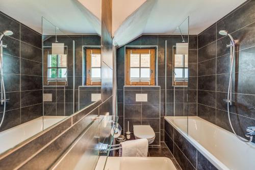 a bathroom with a tub and a toilet and a sink at Chalet #1 am Sonnenhang in Neukirchen am Großvenediger