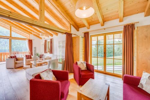 a living room with red chairs and a table at Chalet #1 am Sonnenhang in Neukirchen am Großvenediger
