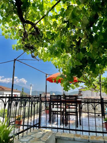a table with an umbrella and chairs on a pier at Guest House Adi Doga in Berat