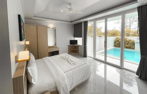 a bedroom with a bed and a swimming pool at Ahimsa Villas in Khao Lak