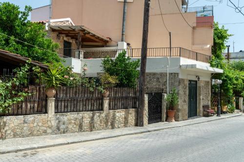 a building with a fence on the side of a street at House Rachati in Zarós