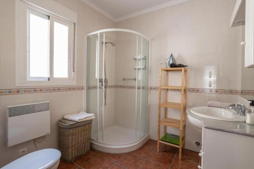 een badkamer met een douche, een toilet en een wastafel bij Villa Flamenca, comoda con piscina privada, barbacoa carril asfaltado by CostaDelSolEscapes in Canillas de Albaida