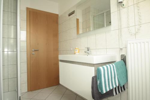 uma casa de banho com um lavatório e um espelho em Ferienhaus Berghaus em Norderney