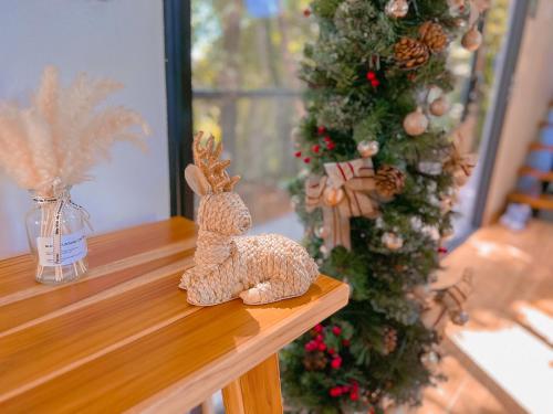 a stuffed animal sitting on a table next to a christmas tree at Amalú Luxury View Cabins in Monteverde Costa Rica