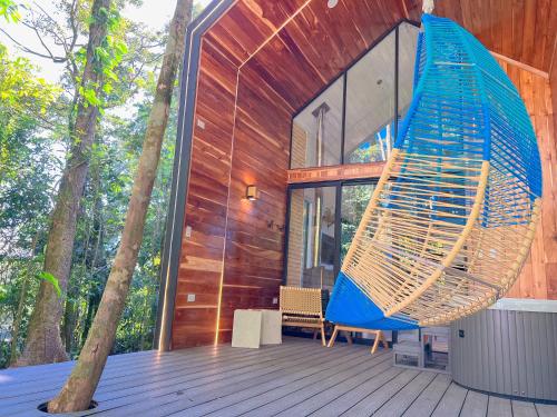 a house with a blue swing on a deck at Amalú Luxury View Cabins in Monteverde Costa Rica