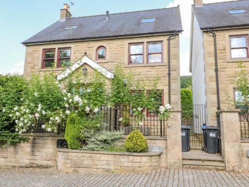 a house with a fence in front of it at The Lillies in Great Rowsley