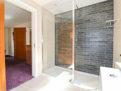a bathroom with a shower with a glass door at The Lillies in Great Rowsley