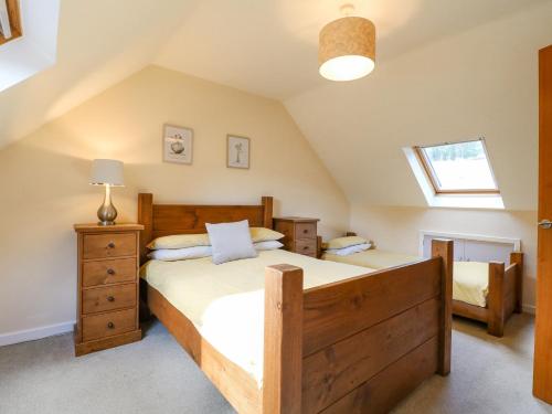 a bedroom with a large wooden bed in a attic at The Lillies in Great Rowsley
