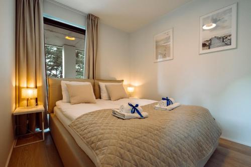 a bedroom with a bed with towels on it at Apartamenty Wydma & Las BlueApart in Jastarnia