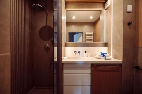 a bathroom with a sink and a mirror at Apartamenty Wydma & Las BlueApart in Jastarnia