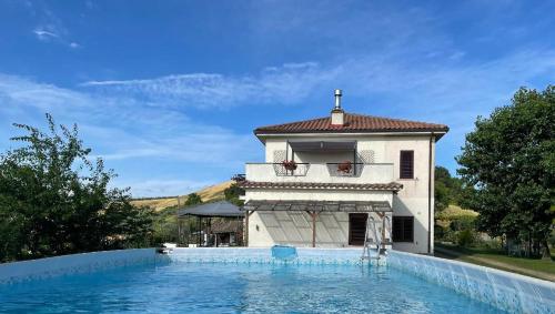 een gebouw met een zwembad voor een huis bij Casa Belfi in Castilenti