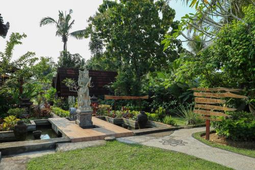 a garden with a statue in the middle of a fountain at The Dukuh Retreat in Tabanan