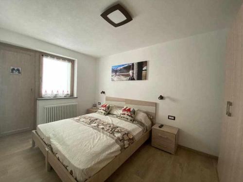 una camera da letto con un letto grande e una finestra di Appartamento Gnomo Livigno a Livigno