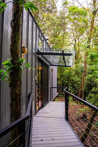 a wooden walkway leading to a house with a tree at Amalú Luxury View Cabins in Monteverde Costa Rica