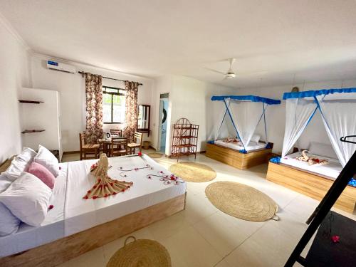 a bedroom with two beds and a living room at TIANDE Boutique Hotel in Pwani Mchangani