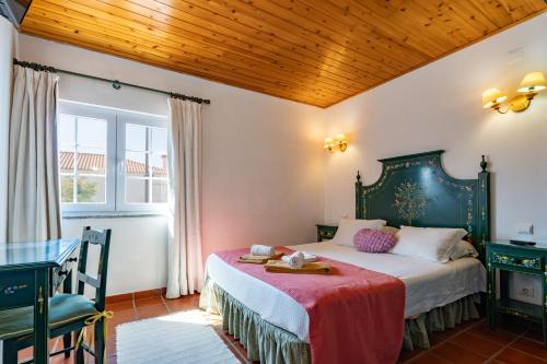 a bedroom with a bed and a table at Hotel Mar e Sol VNMF by Umbral in Vila Nova de Milfontes