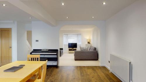 a kitchen and living room with a couch and a table at Woodlands in Charlbury