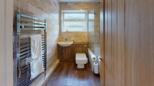 a bathroom with a toilet and a sink and a window at Woodlands in Charlbury