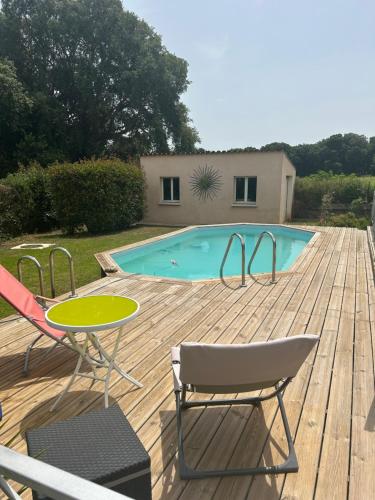 une terrasse avec une piscine, 2 chaises et une table dans l'établissement Entre Mer et Montagne, à Venzolasca