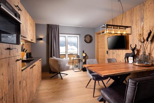 eine Küche und ein Esszimmer mit einem Holztisch in der Unterkunft Schöneben Appartements in Wald im Pinzgau