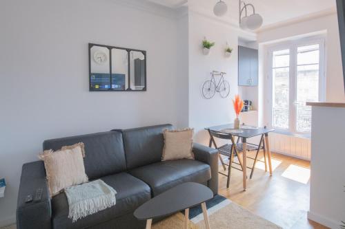 un soggiorno con divano e tavolo di Paris Bercy - Charming Apartment 2 rooms a Parigi