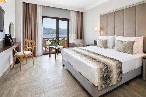 a hotel room with a large bed and a balcony at Elite Hotel Yalıkavak in Yalıkavak