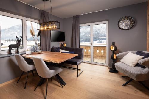ein Esszimmer mit einem Holztisch und Stühlen in der Unterkunft Schöneben Appartements in Wald im Pinzgau