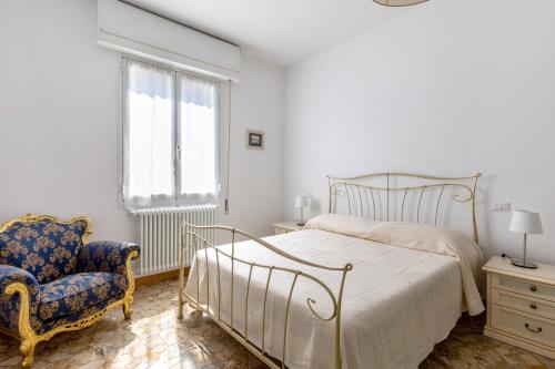 ein Schlafzimmer mit einem Bett, einem Stuhl und einem Fenster in der Unterkunft A Casa di Giorgia by Wonderful Italy in Bologna