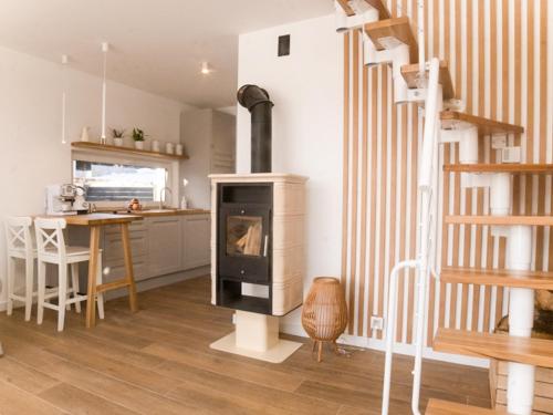 a living room with a fireplace and a kitchen at Warmiński Sad in Olsztyn