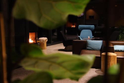 a living room with couches and a blue chair at Hotel Soča in Bovec