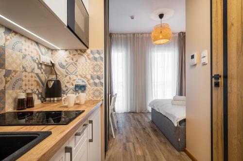 kuchnia ze zlewem i łóżko w pokoju w obiekcie AYCON APARTMENTS - WOLA TOWER w Warszawie