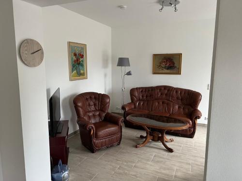 a living room with two leather chairs and a television at Zum Rosental in Rötha