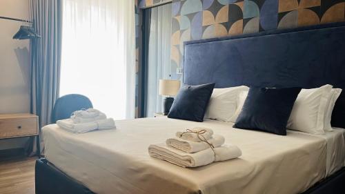 1 dormitorio con 1 cama grande y toallas. en Palazzo Gatto Bianco en Bari