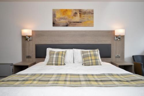 a bedroom with a bed with two night stands and two lamps at Fyne Rooms in Tighnabruaich