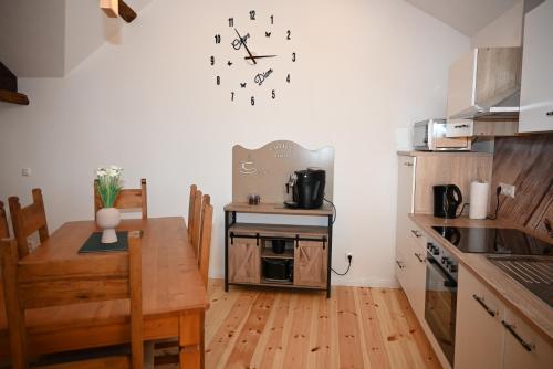 cocina con mesa y reloj en la pared en Ferienwohnung Rapunzel, en Nideggen