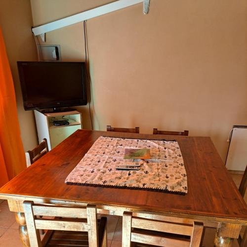 mesa de madera con sillas y sidra de mesa en Departamento uspallata en Uspallata