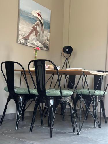 a dining room table with chairs and a painting on the wall at Kuća Aurora in Rovinj
