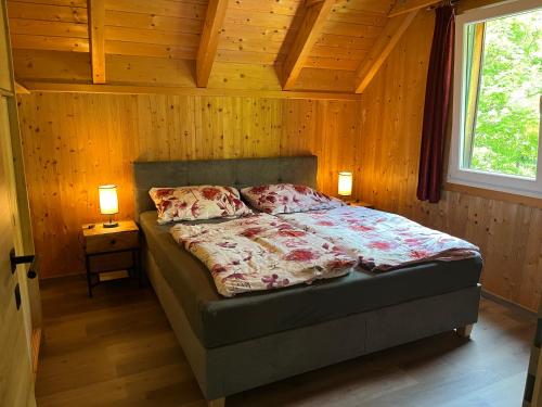 a bedroom with a bed with two lamps and a window at Alpenferienhaus Sophia in Sankt Lorenzen ob Murau