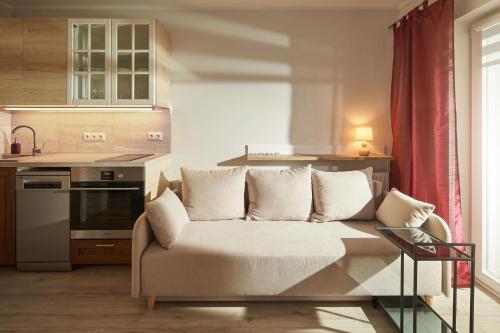 a living room with a couch in a kitchen at Symphony City Square Aparthotel in Wrocław