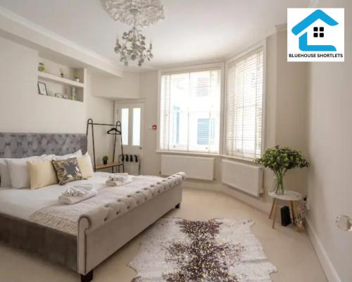 Un dormitorio con una cama grande y una lámpara de araña. en Three Bedroom Apartment At Bluehouse Short Lets Brighton With Garden Family Leisure, en Brighton & Hove