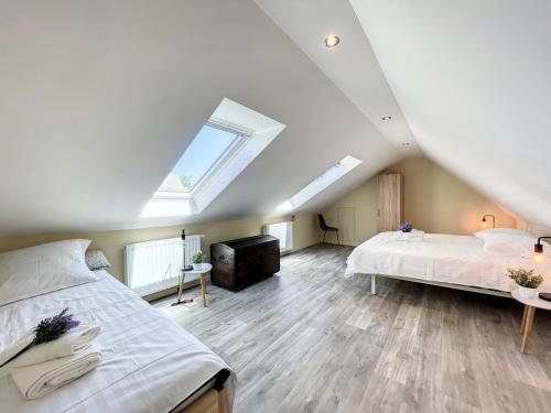 a attic bedroom with two beds and a skylight at STKE - holiday home for 8 in Veurne